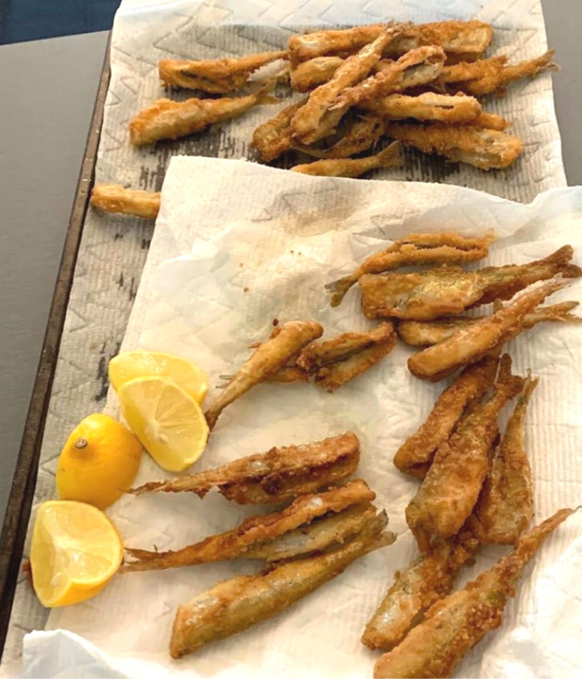 freshly friend lemon batter fish on paper towels with lemons