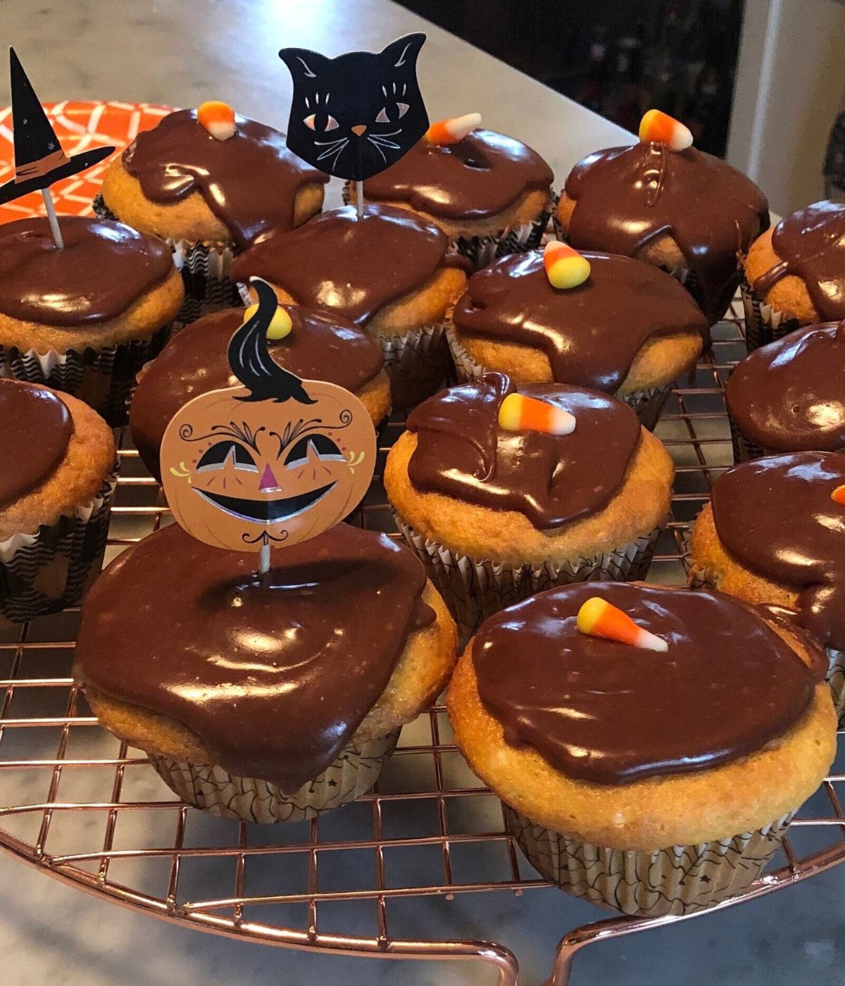 vanilla cupcakes with chocolate frosting on a cooling rack